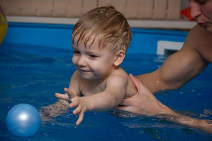 ребенок учится плавать